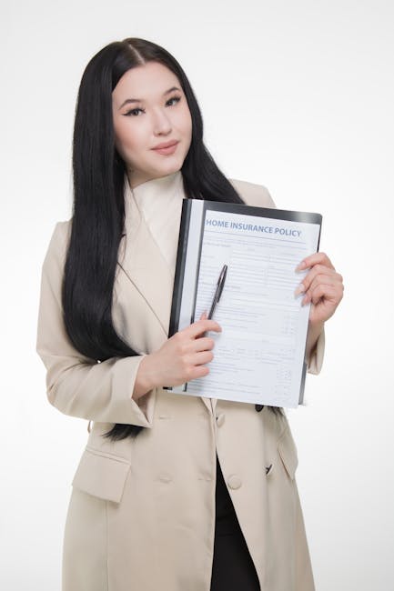 A person holding a pen above a clipboard with a printed home insurance policy form, which is positioned on their lap during a home relocation or furniture transport process. The form includes sections